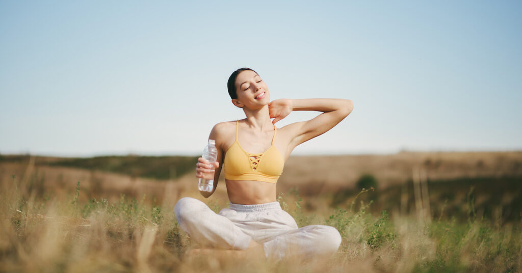 woman sitting in field happy and healthy