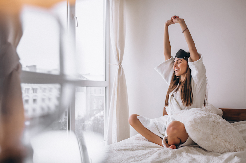 Woman in bed wearing sleeping mask