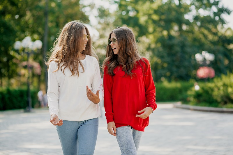 Two ladies smiling while walking together